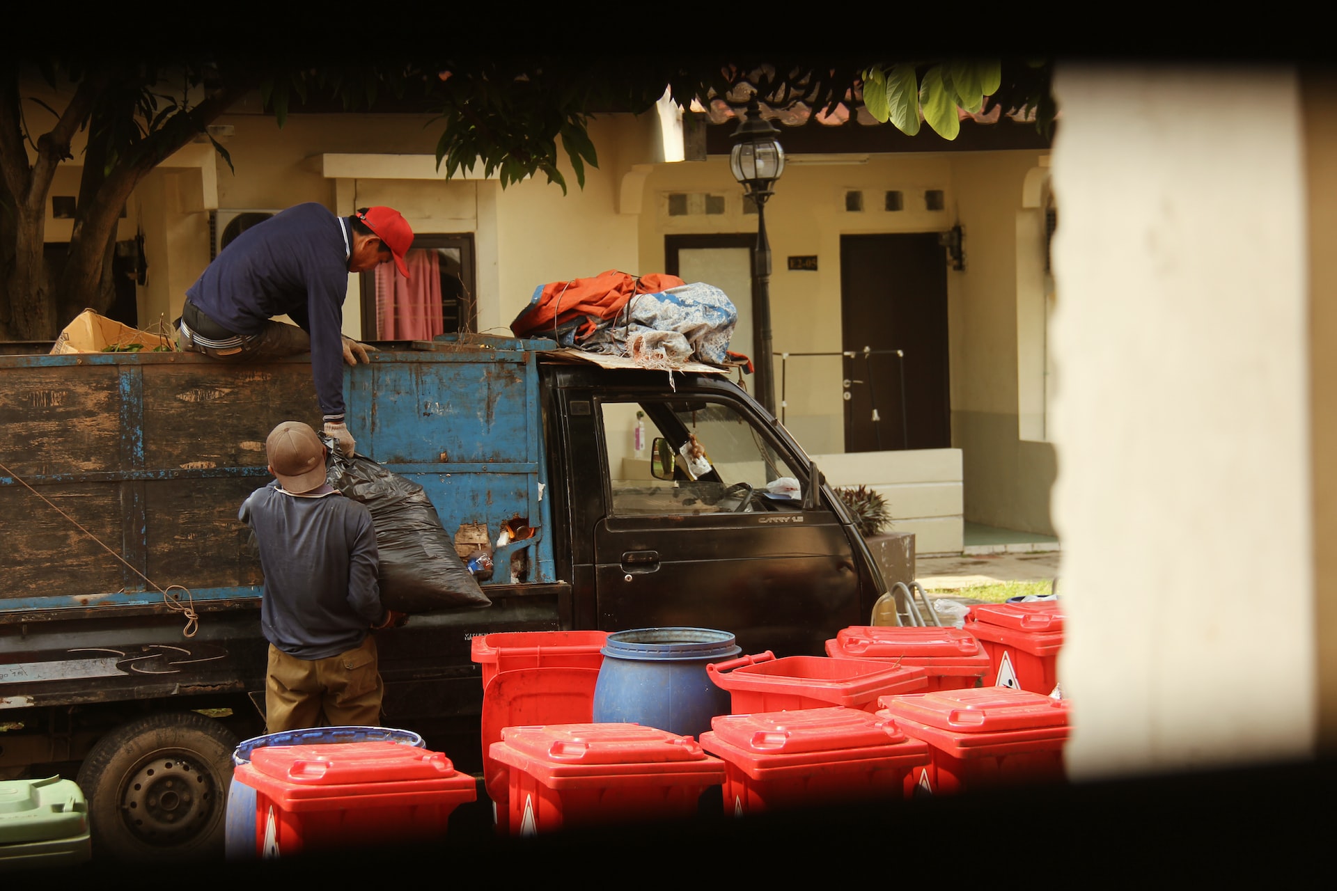 dump truck beside red garbage bins